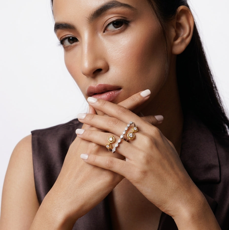 Woman wearing multiple rings on her fingers with a neutral background
