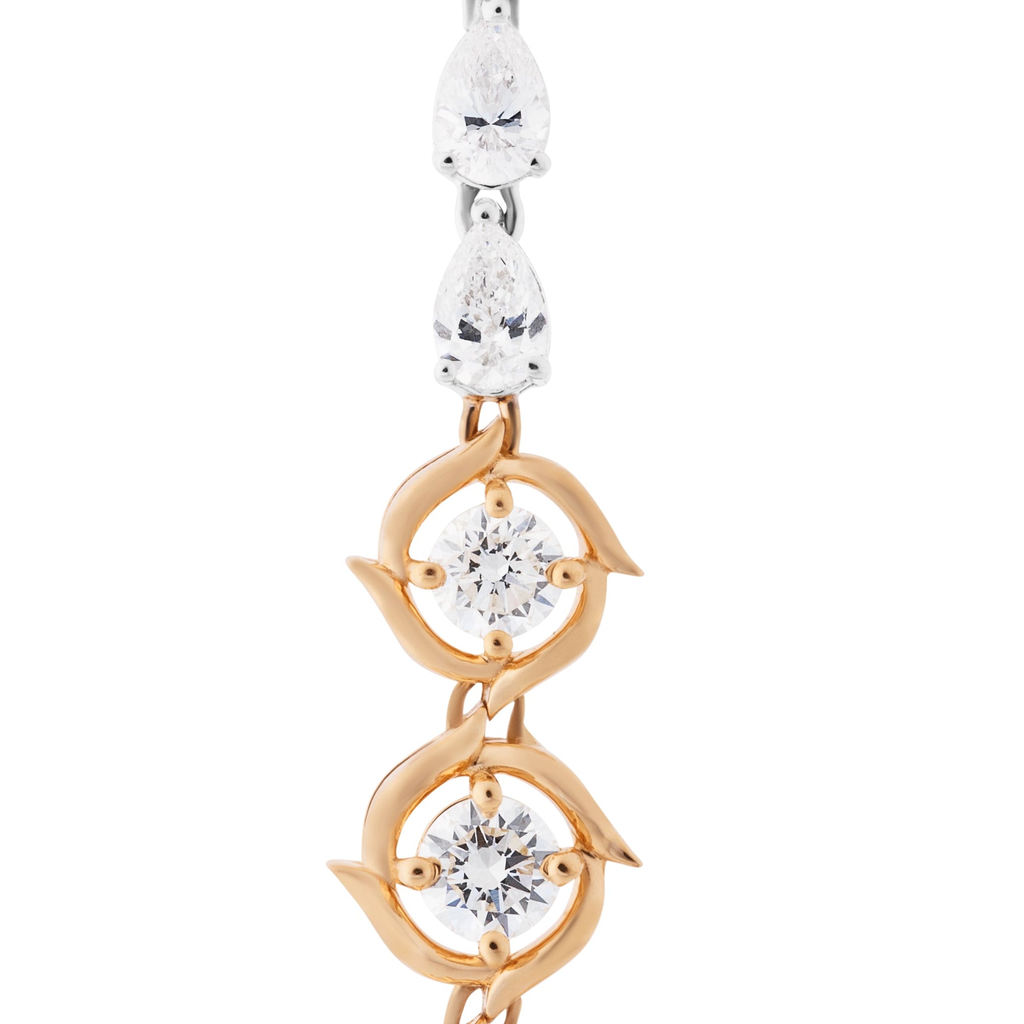 Pair of gold and rose gold earrings with clear gemstones on a white background