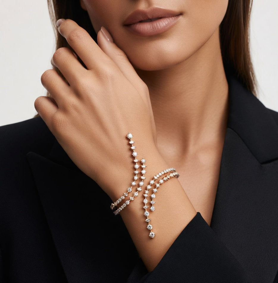 Close-up of a woman wearing a delicate bracelet on a neutral background