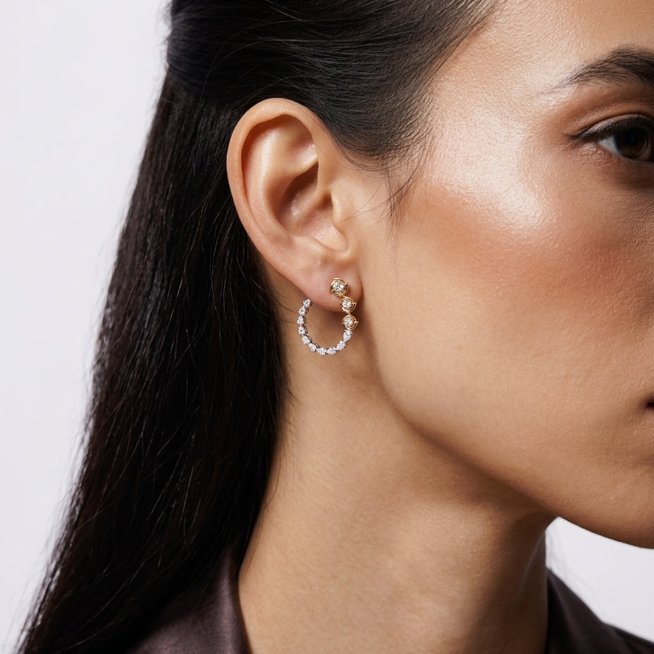 Close-up of a woman wearing a silver hoop earring with a white background