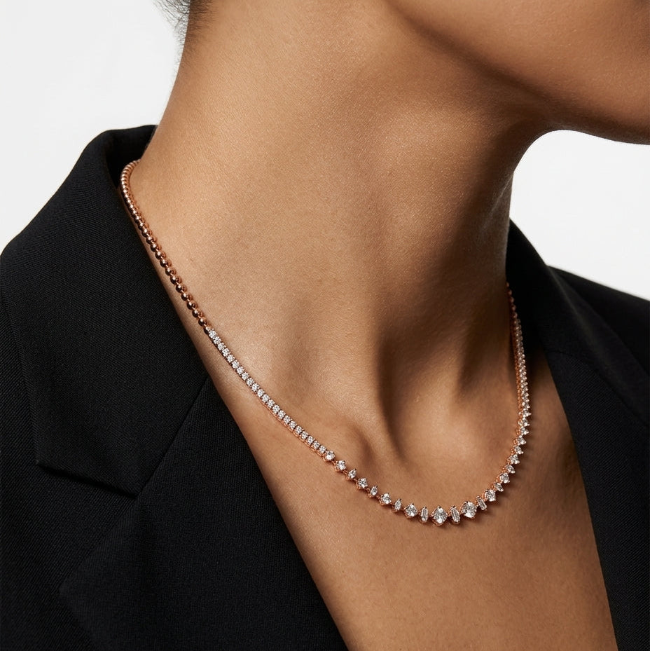 Necklace with small diamonds on a person wearing a black top against a white background