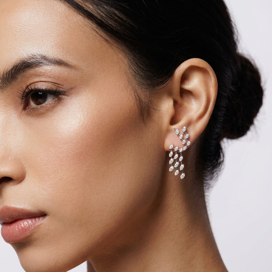 Close-up of a woman wearing sparkling earrings against a neutral background