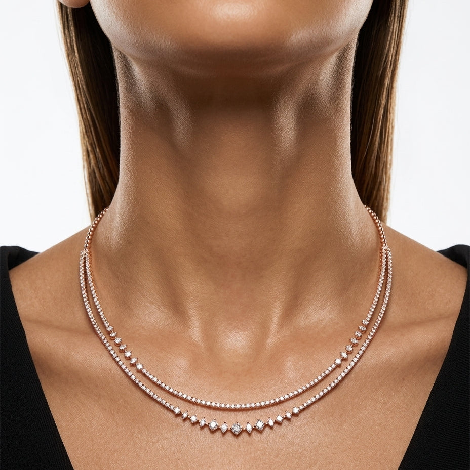 Close-up of a woman wearing a delicate necklace with a neutral background